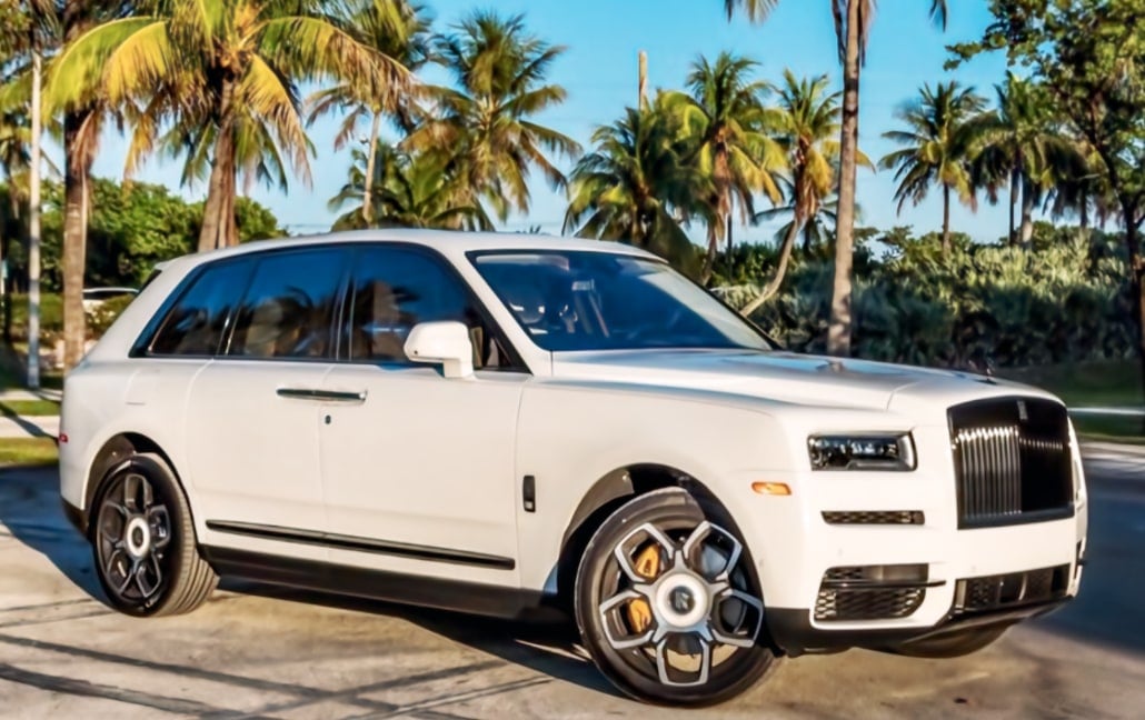 White Rolls-Royce Cullinan photographed beneath palm trees